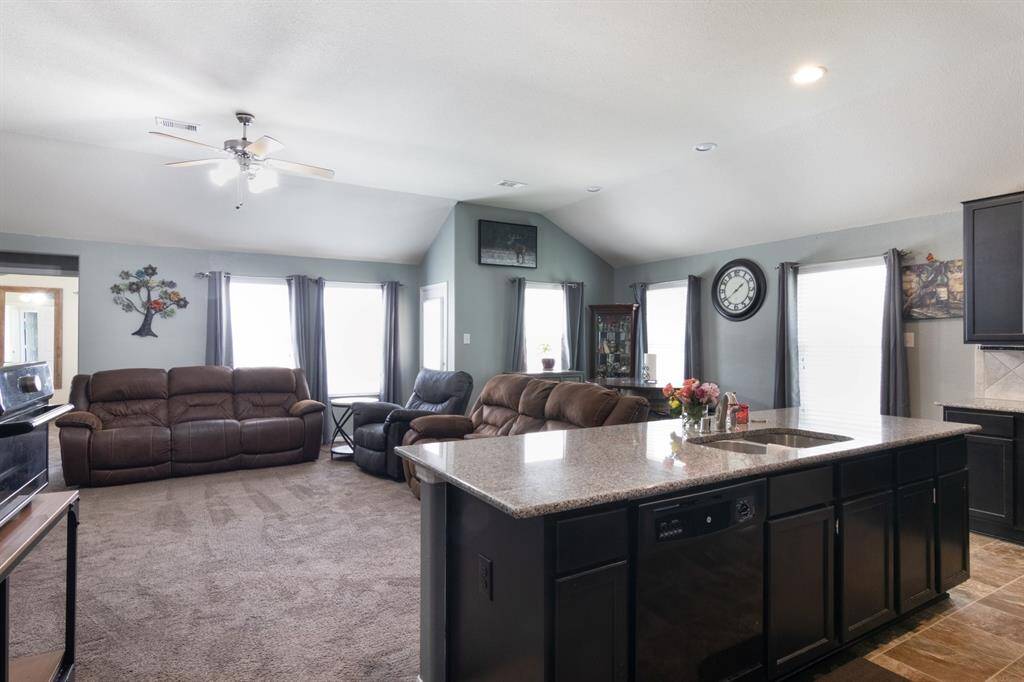 Large Kitchen island with granite countertops.