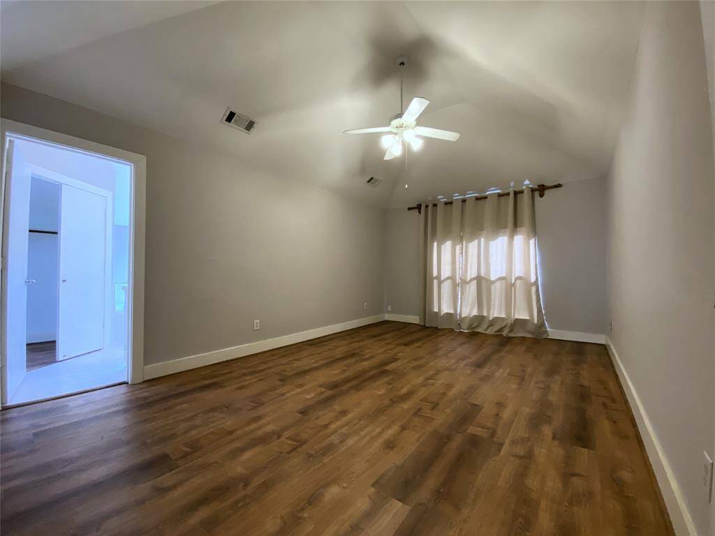 The primary bedroom with high ceiling & ceiling fan with dimmer controlled light fixture.