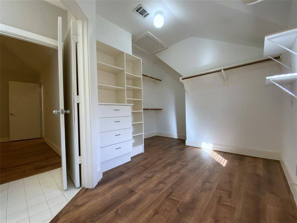The primary walk-in closet offers built-in storage and ample hanging.