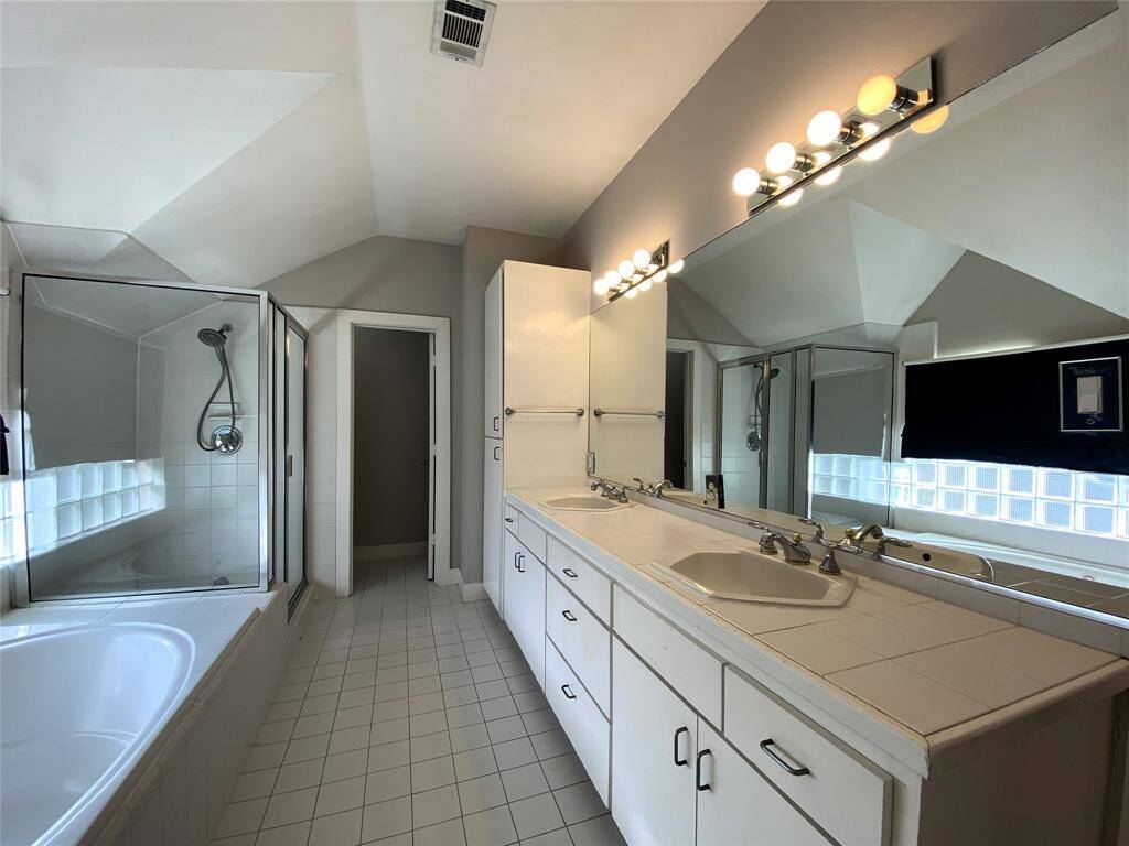 Extended double sink vanity, jetted tub, separate shower and dimmer controlled lighting.