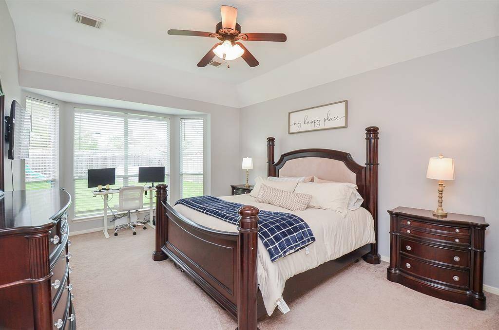 King sized primary suite ... with windows lining the walls.  Updated fan and neutral soft paint.