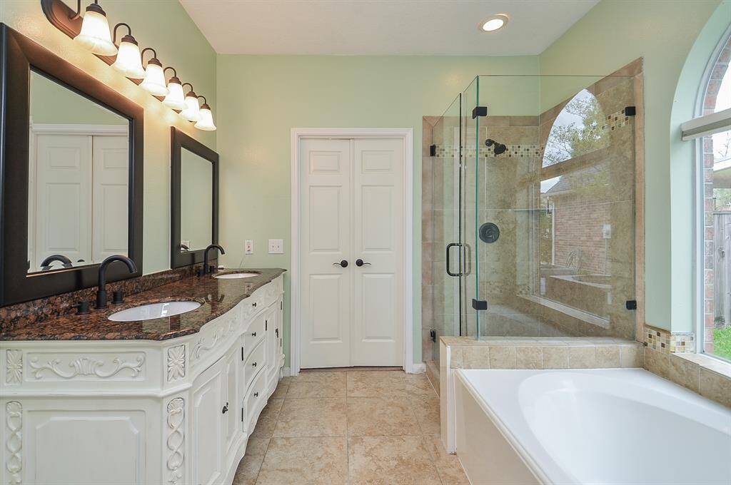 Updated and beautiful.  Seamless separate shower.  Ornate cabinetry.  Granite counters.  Tile flooring ... make this bathroom fit for a king and queen.