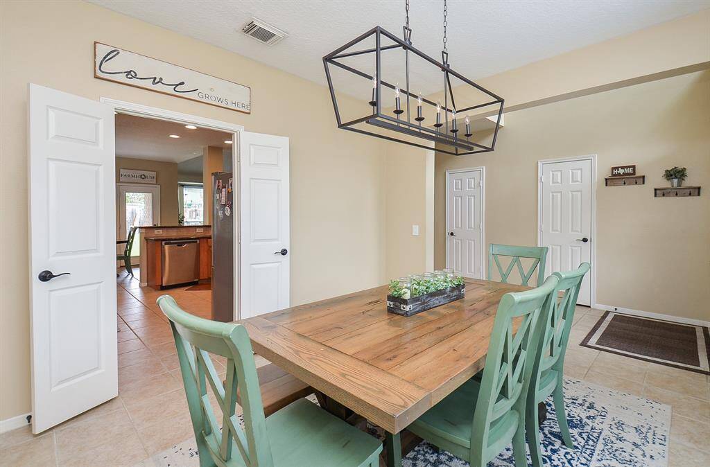 This large dining area is right off the kitchen making entertaining easy.  Stately french doors and crisp neutral paint.