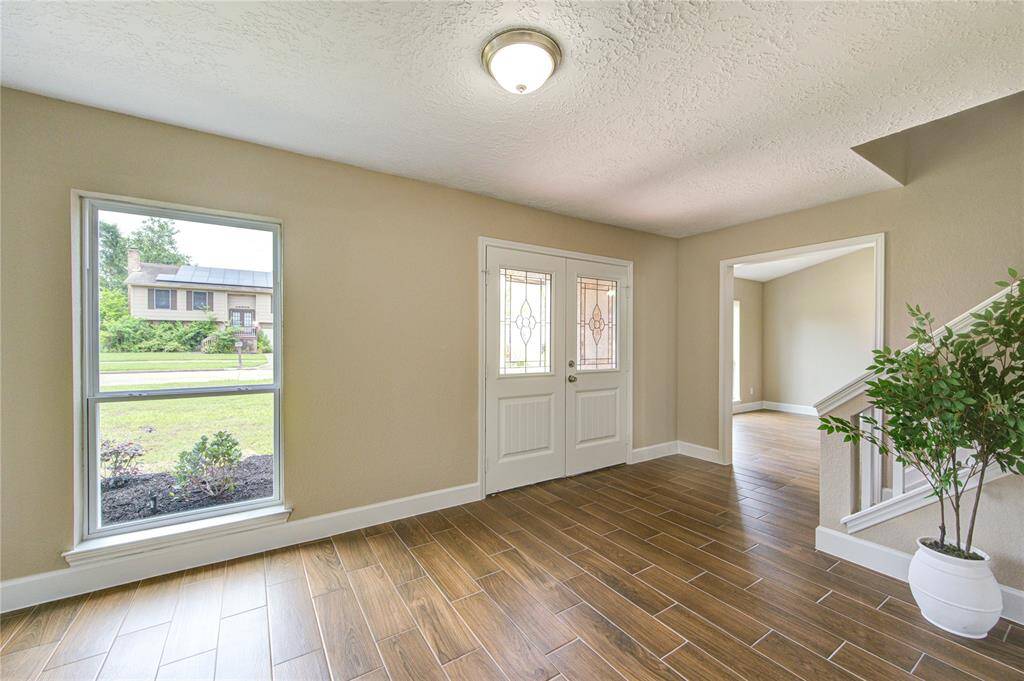 What a beautiful entryway! It features large windows allowing plenty of natural light, offering a warm and inviting first impression.