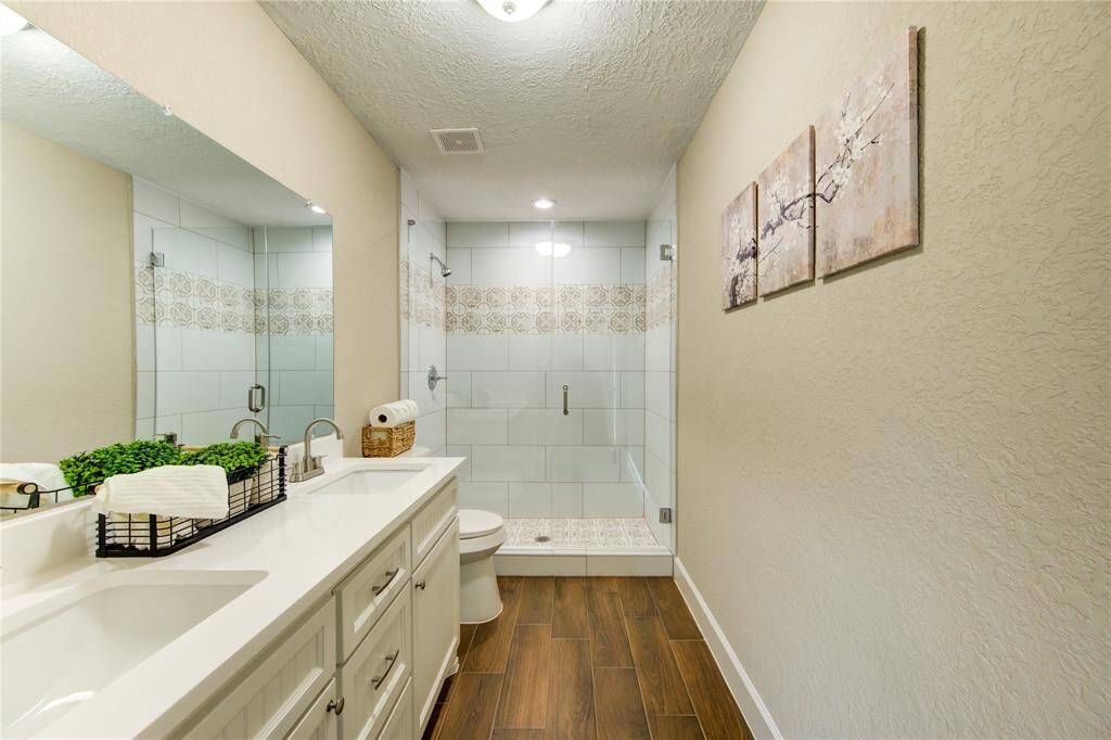 The primary bath includes a dual sink vanity space and custom built cabinetry.