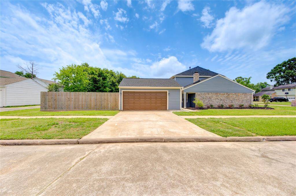 View of the side of the house featuring a two-car garage with a double-wide driveway. Plenty of space for your vehicles!
