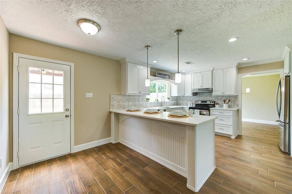 Another view of the kitchen showing the door leading to gorgeous back yard!