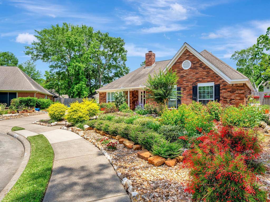 The front of this charming red brick home is beautifully landscaped with vibrant flowering bushes, including Jatropha, roses, and milkweed, creating a welcoming and colorful curb appeal. A professionally installed weed barrier lies beneath all plantings, ensuring a clean, well-maintained appearance year-round and enhancing the overall beauty of the space.