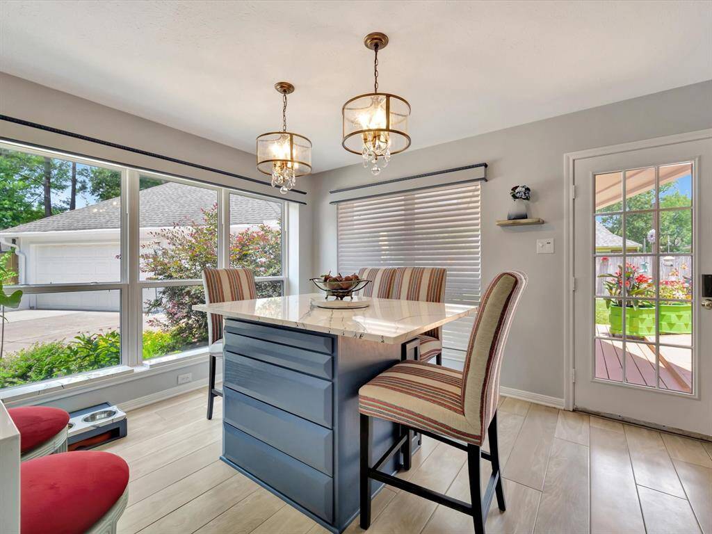 The cozy breakfast area features a built-in quartz countertop with ample storage in the base cabinets, perfect for casual dining and everyday convenience. Large windows flood the space with natural light, beautifully framed by a custom valance that adds an elegant finishing touch