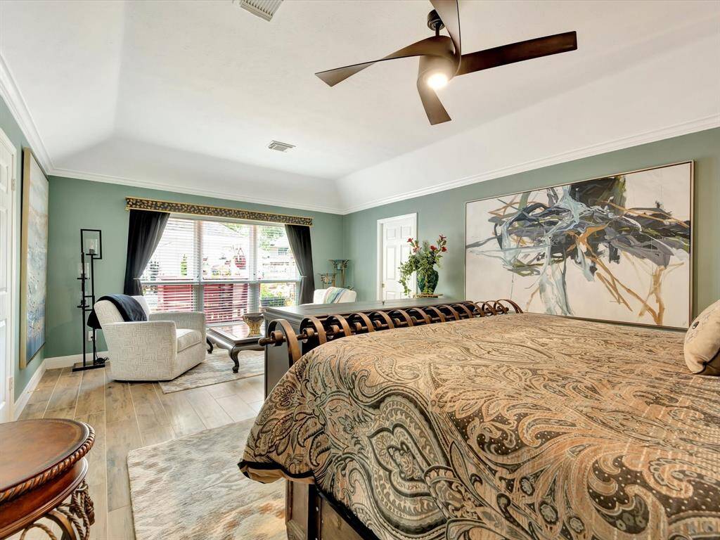 A cozy seating area graces the primary bedroom, positioned beneath a large window that fills the space with natural light. The window is beautifully adorned with a custom valance, adding a refined and personalized touch to this relaxing nook.A cozy seating area graces the primary bedroom, positioned beneath a large window that fills the space with natural light. The window is beautifully adorned with a custom valance, adding a refined and personalized touch to this relaxing nook.