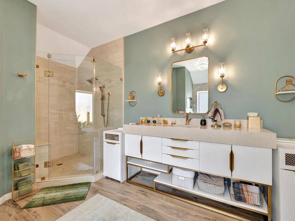This is one of the primary closet that is thoughtfully designed with push-to-open drawers in varying sizes, providing versatile and streamlined storage. Open shelving beautifully displays shoes and bags, while decorative gold pulls add a touch of elegance and sophistication to the overall design