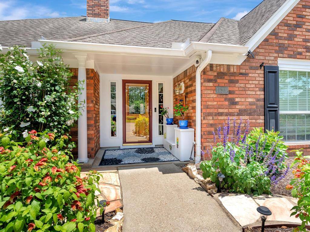 The covered front porch offers a welcoming and shaded entrance, complete with a storm door for added protection and a sleek, modern lead glass front door. A built-in delivery box provides a secure and convenient solution for receiving packages, blending functionality with curb appeal.