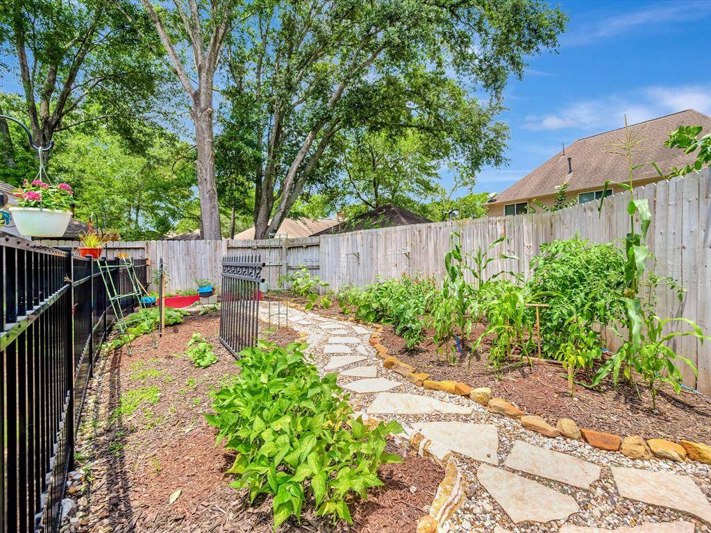 Vegetable garden fenced and gated with stone walk way