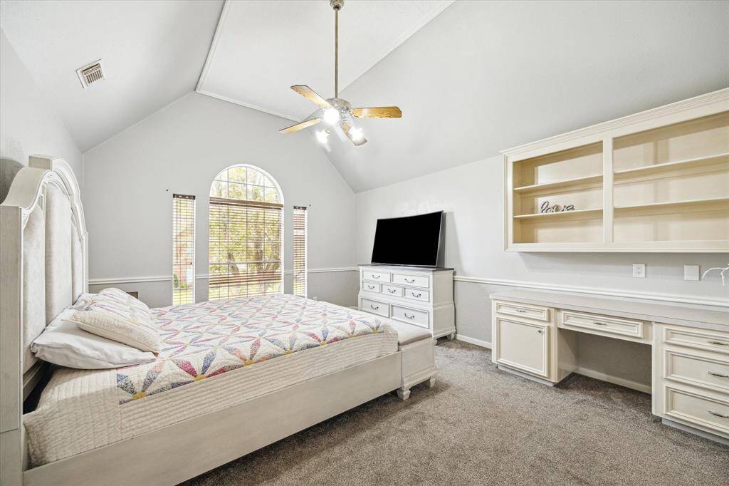 Very spacious secondary bedroom on the second floor, featuring a built-in desk, high ceilings, and a large window that floods the room with natural light.