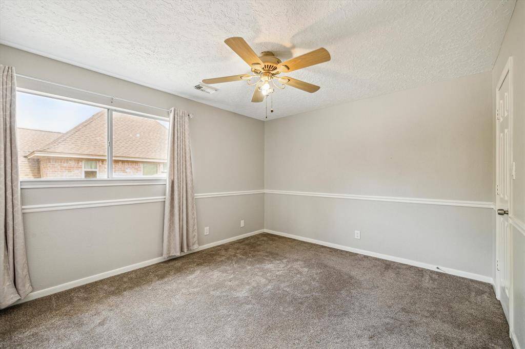 View of another spacious secondary bedroom on the second floor, perfect for family or guests.