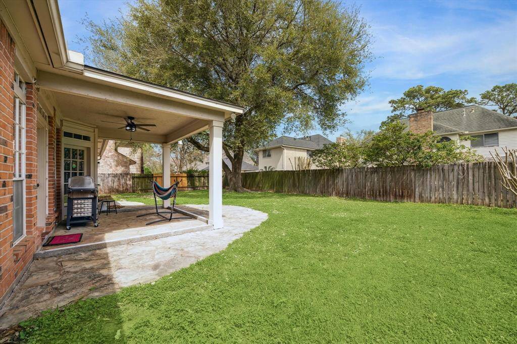 Spacious backyard with a covered area, perfect for enjoying your morning coffee or sharing meals outdoors.