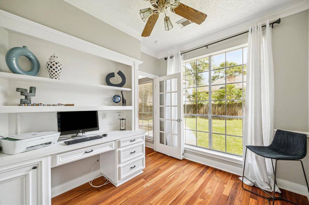 Recently remodeled study or home office featuring a built-in desk, spacious closet, and a large window that fills the room with natural light and offers views of the backyard.
