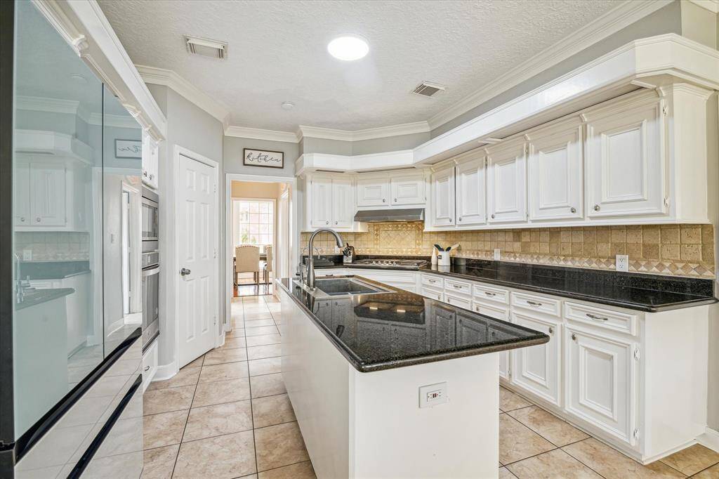 Modern kitchen with all-new stainless steel appliances and a striking black granite countertops.