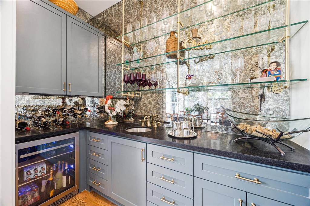 Luxurious wet bar set perfectly next to the dining room with a beverage refrigerator.