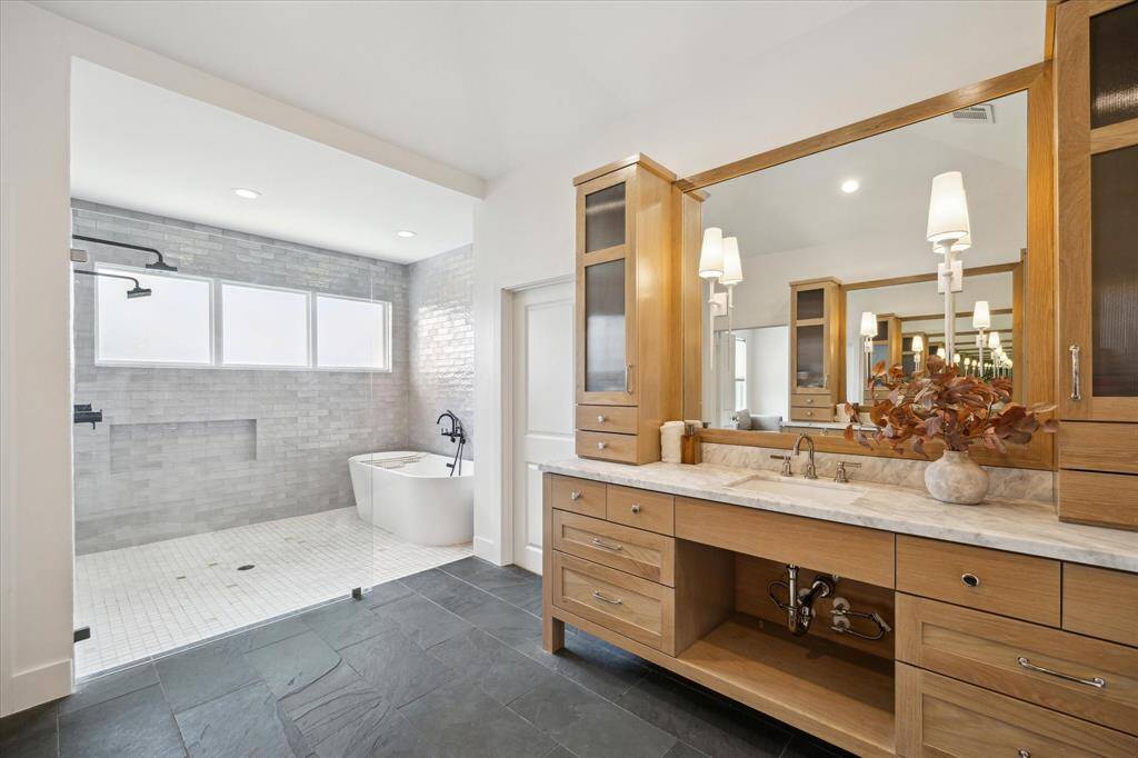 This spa-like primary bathroom has dual shower heads and an all marble shower.