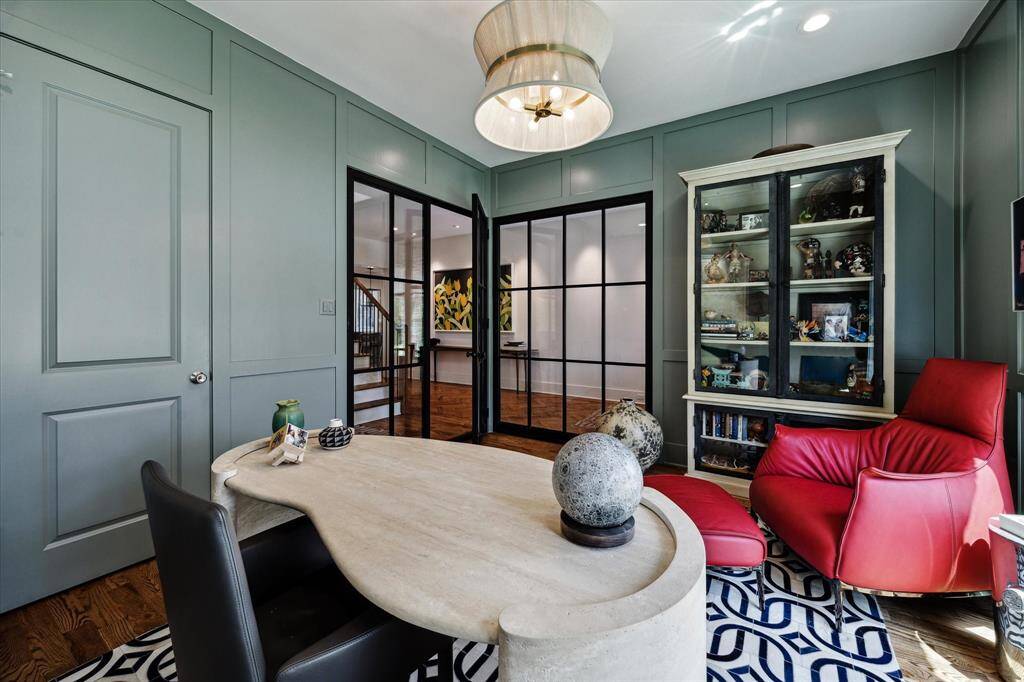 This custom office features glass panes, custom shelving, closet space, and designer lighting.