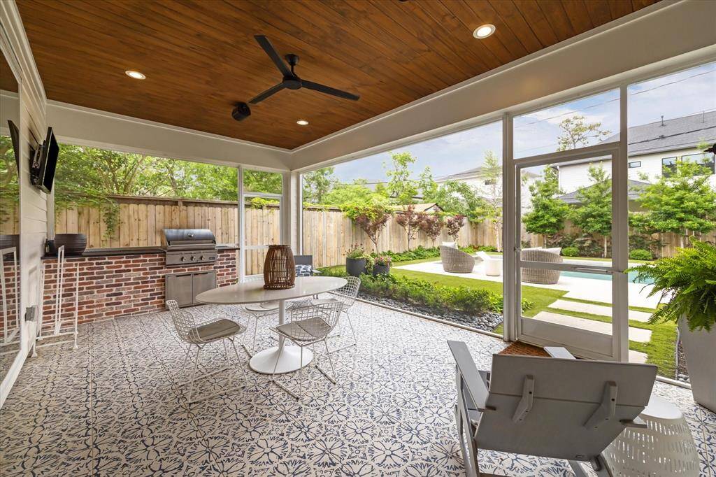 Summers just got sweeter with this screened-in porch and outdoor grill with a fun tile pattern and a tongue and grove ceiling.