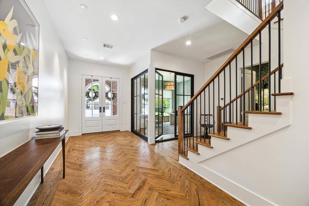 As you enter, you are greeted with herringbone patterned oak floors and a grand staircase.