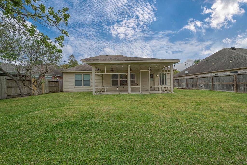 The super lush and green backyard with covered patio is a perfect place for your kids and pets to play.