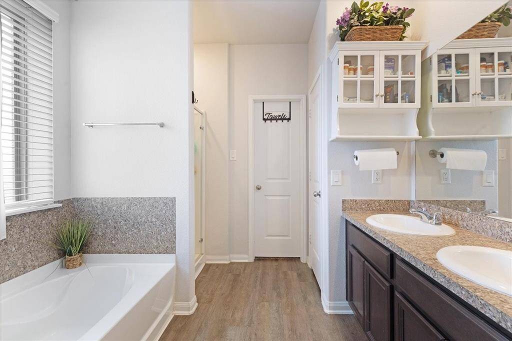 Step into your spa-like en-suite through grand double doors—featuring a soaking tub, walk-in shower