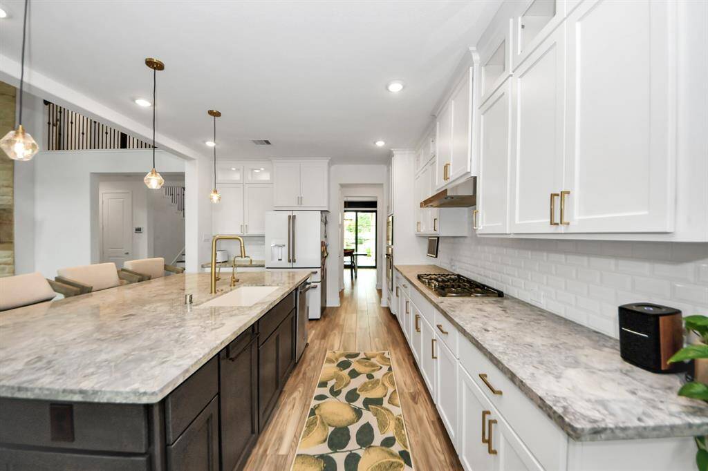 Plenty of cabinet space and beautiful upgraded quartzite counter tops with Arhaus pendant lights.  Cafe refrigerator included in sale.