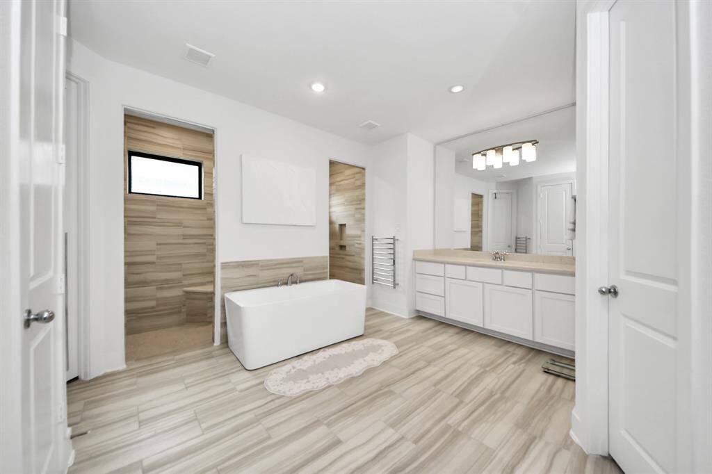 Look at this amazing primary bathroom retreat with his and hers towel warmers.