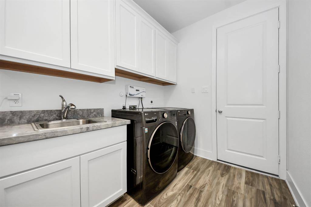 Laundry room with built-in sink and ozone generator add-on for extra cleaning and freshness.  Washer and dryer included in the sale.