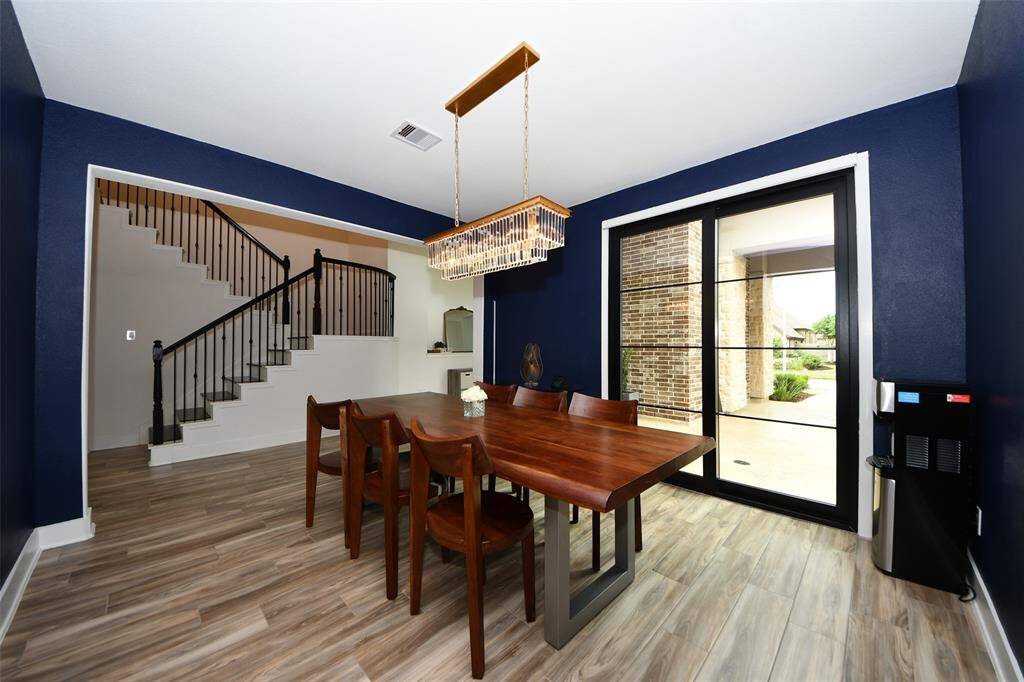 View of the formal dining room with upgraded lighting, access to the outdoor foyer and adjacent butler's pantry.
