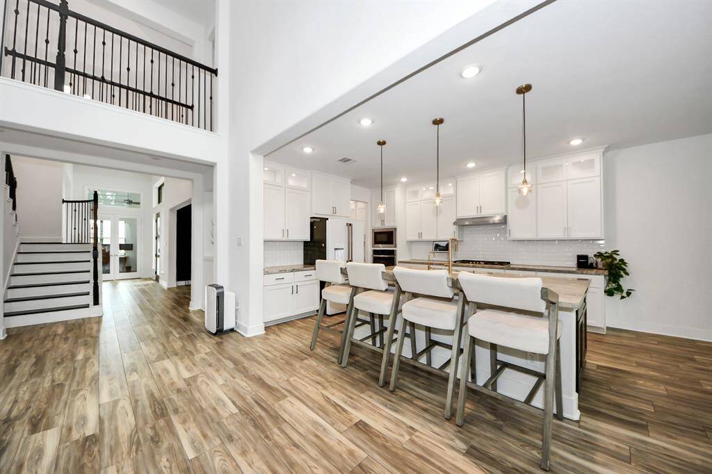 View from the family room to the gorgeous kitchen, entry way and office.