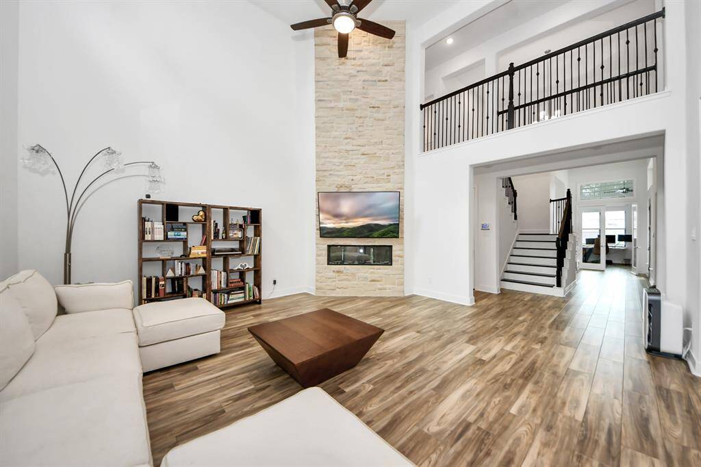 Modern and stylish fireplace, encased by stone that extends up to the second floor.