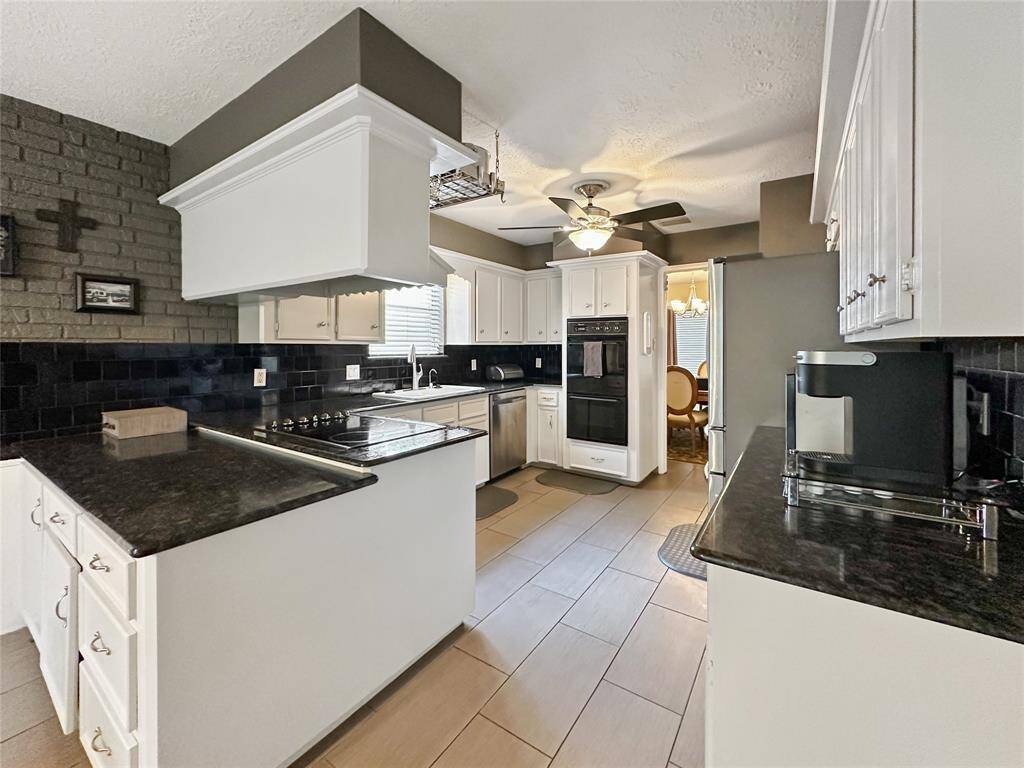 This kitchen boasts ample counter space and cabinetry, offering the perfect setup for meal prep, hosting, or casual family dining.
