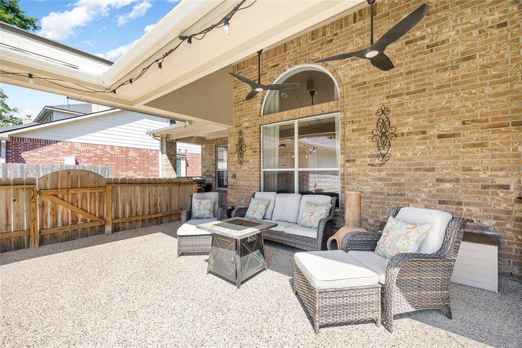 This photo showcases a cozy outdoor patio area. The space is enclosed by a wooden fence.
