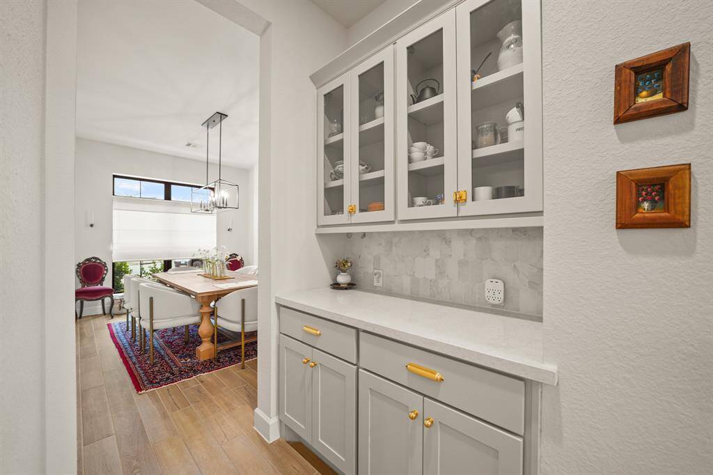 The Butler’s Pantry, with it's glass display cabinets & marble backsplash, offers both charm & utility as it connects the Kitchen to the Dining Room, ideal for hosting & serving.