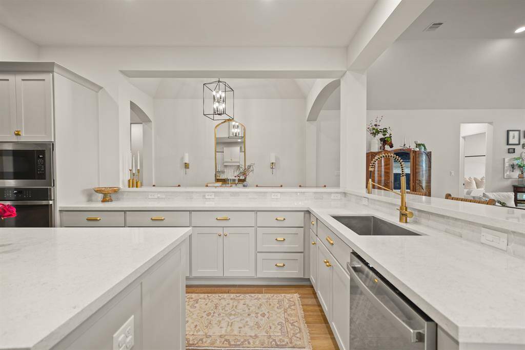 Thoughtfully designed Kitchen features a Breakfast Bar, Stainless Undermount Kitchen Sink, Soft Close Kitchen Cabinets & Drawers, Rejuvenation Hardware, & a Professional Gold KRAUS Kitchen Faucet.