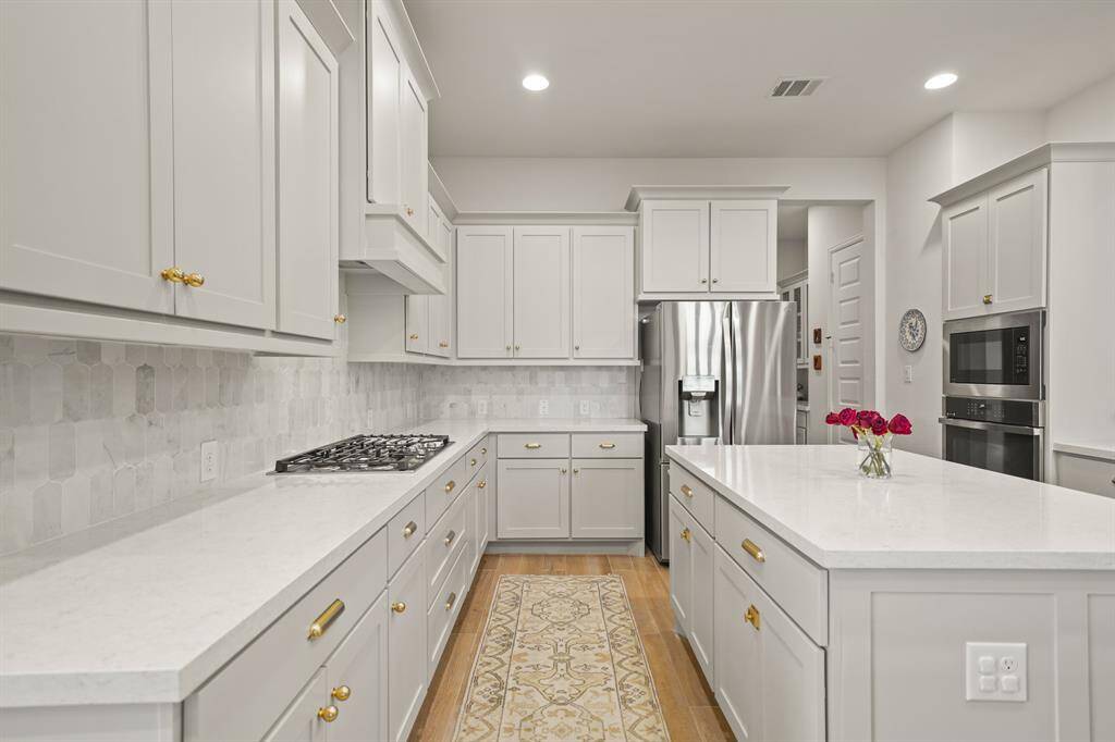 The bright Kitchen combines style & function with recessed lighting, abundant natural light, a sleek 5-burner recessed gas cooktop, & a bank of 2 drawers in place of a lower cabinet door & drawer — ideal for everyday cooking & entertaining.