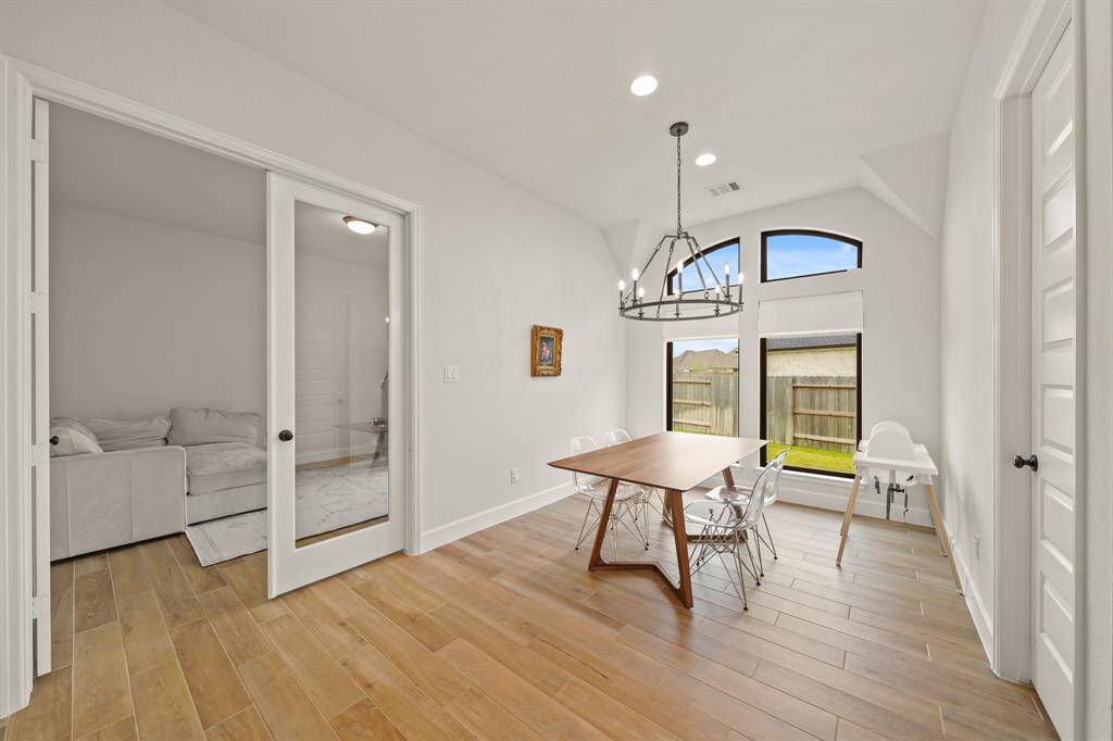The bright Breakfast Room, illuminated by a stylish Landon Smith Chandelier, sits just steps from the Game Room — creating an open & connected space for dining & play.