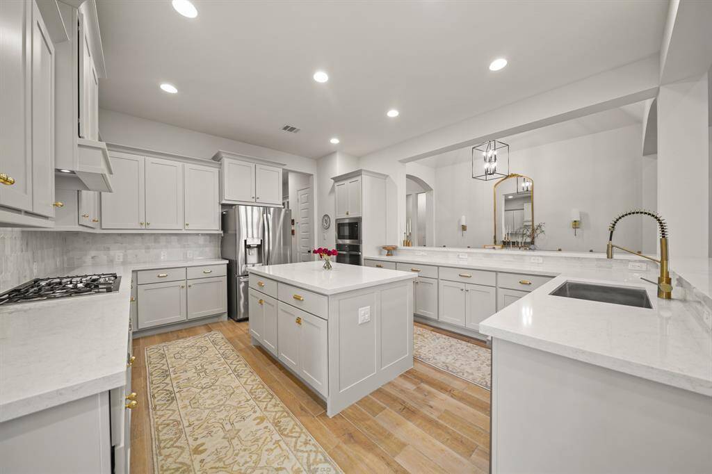 The Kitchen is the heart of the home & features timeless Upgraded Cabinetry, Quartz Countertops, Polished Marble Backsplash, a center island & offers lots of storage space.