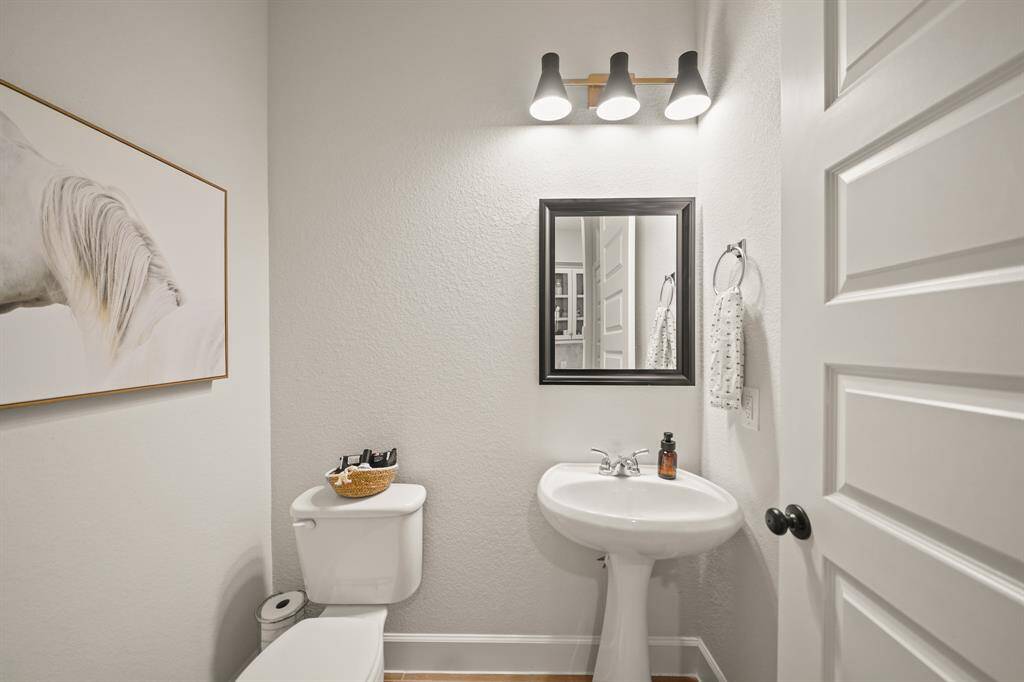 Stylish Half Bath featuring a pedestal sink offers a convenient & elegant space & is ideal for guests & quick use.