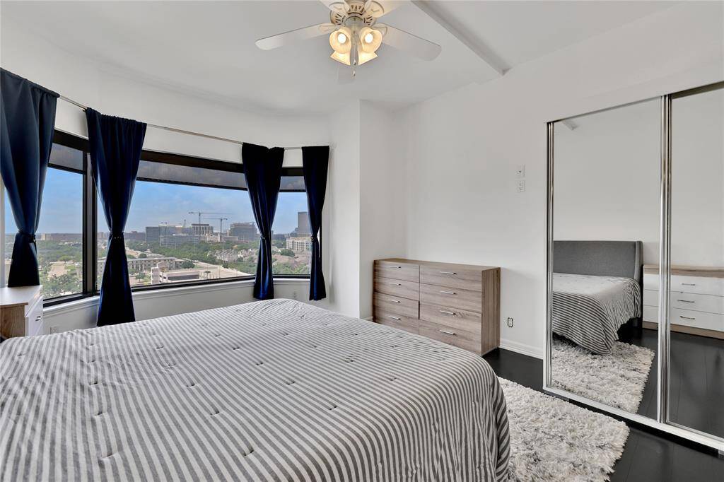 One more look in the primary bedroom toward the bay window which has pull down shades and curtains.