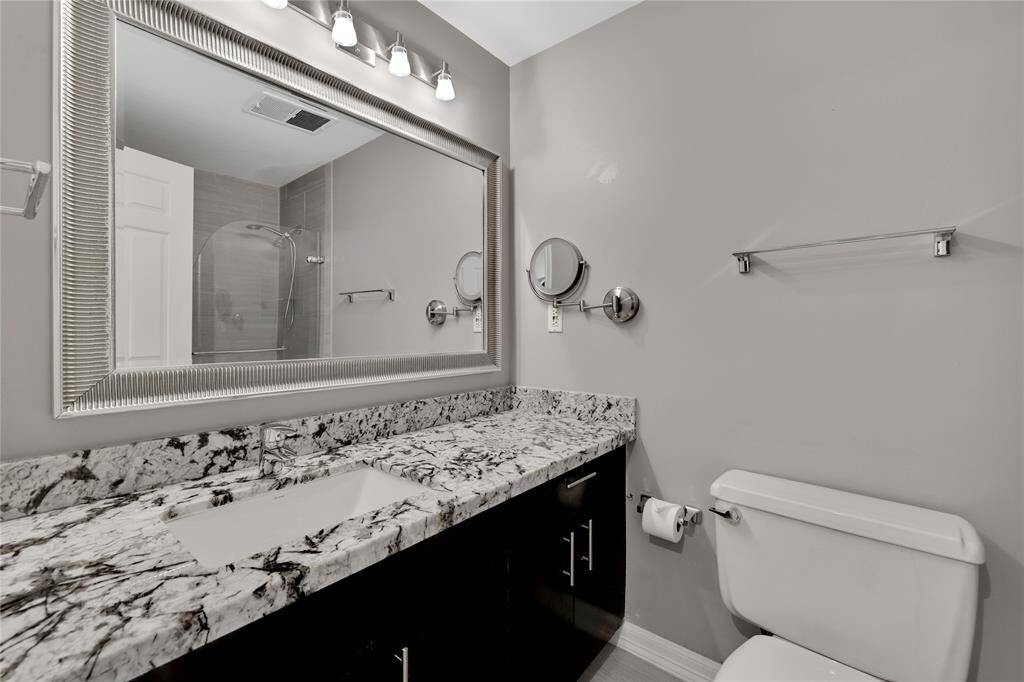 The secondary bathroom has an updated vanity with a granite counter top.