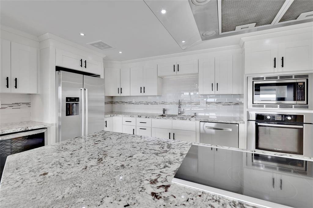 The bright and airy kitchen has a complete stainless steel appliance package including a wine fridge. Notice all the countertop space ideal for meal prepping.