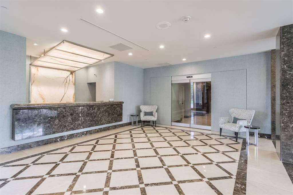 Spacious building lobby with concierge desk.