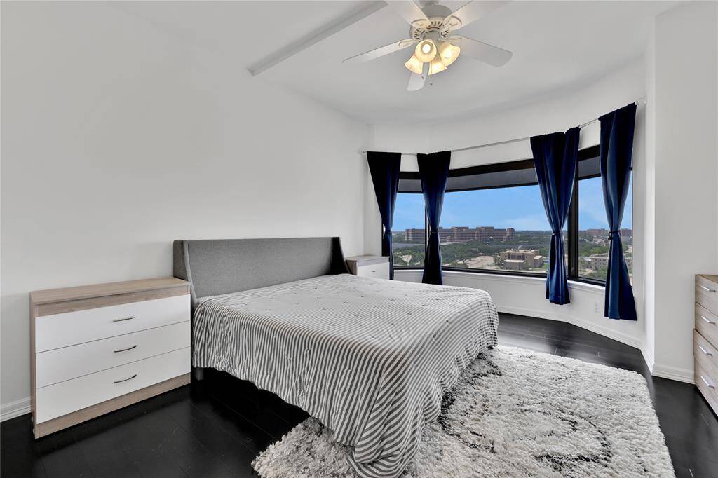 The primary bedroom features a king size bed, nightstands, bamboo flooring, rug, dresser and sliding door wardrobe.