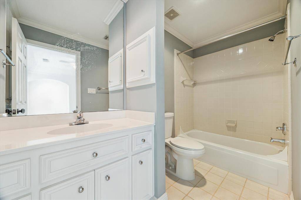 Secondary bathroom with tile floors, recessed lighting, crown molding and a tub/shower combo.