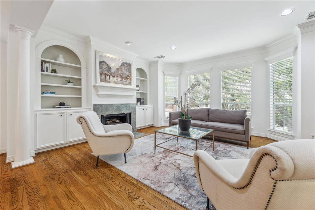 This elegant living space is anchored by a stately fireplace flanked by built-in shelving.